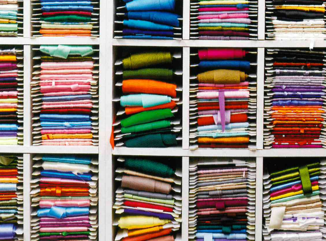 A close up of a shelf filled with lots of colorful clothing