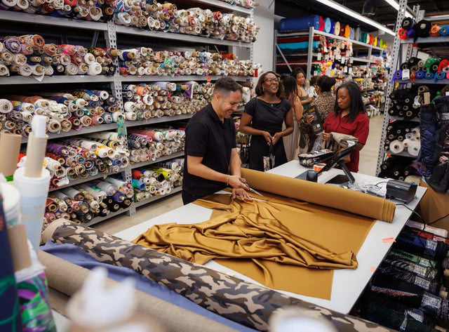 People are looking at a large roll of fabric in a store