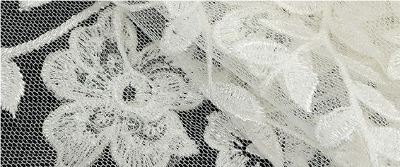 A close up of a white lace on a black background