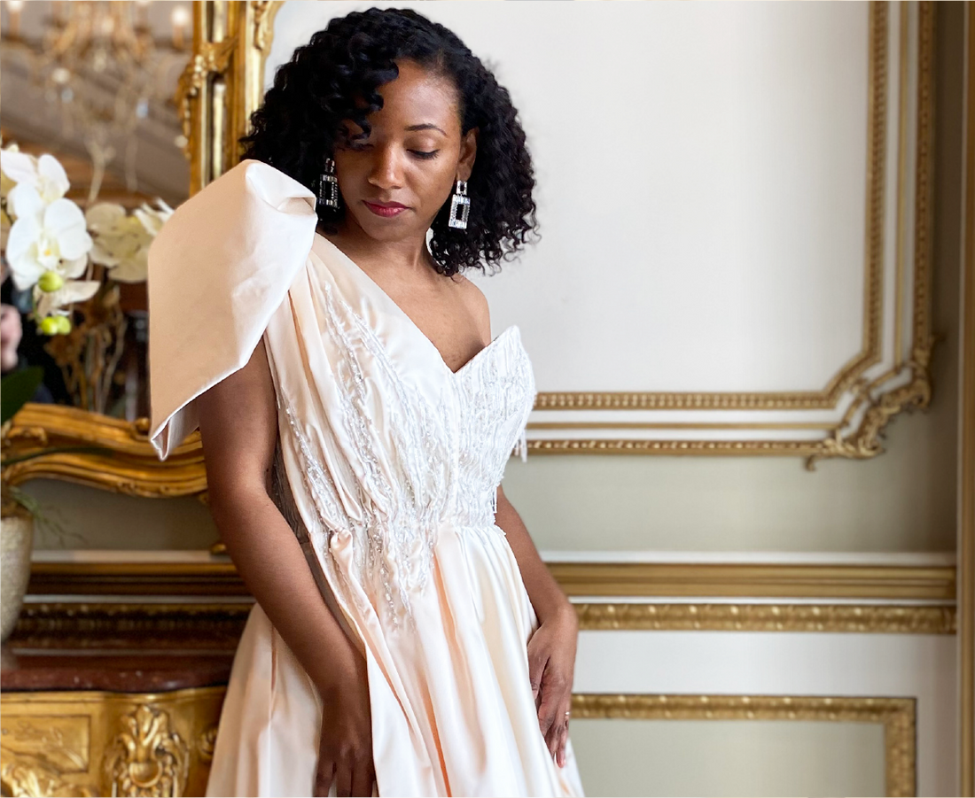 A woman in a dress standing in front of a mirror