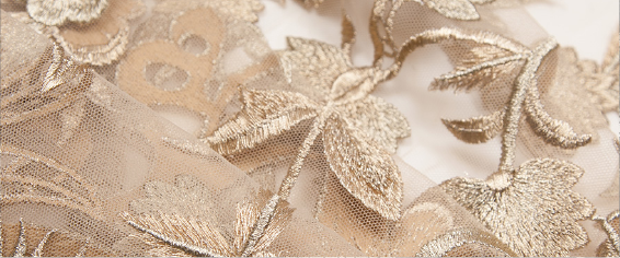 A close up of a gold dress with a floral pattern