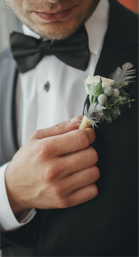 Man in a tuxedo adjusting his boutelloer