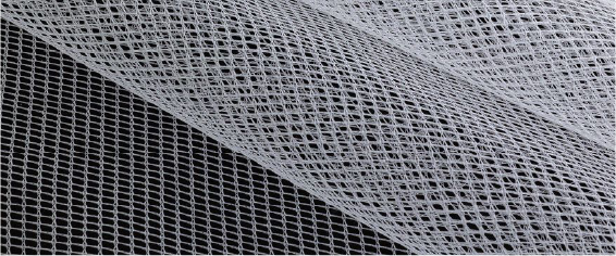 A close up of a piece of white mesh with a black background