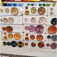 a rainbow of colorful buttons in various sizes on display in a store