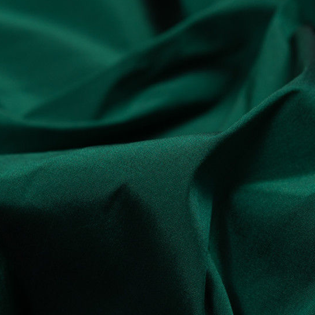 A close up of a green cloth with a black background