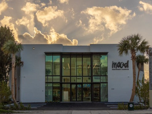 View of a building with a sky background and palm trees