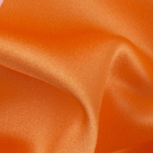 A close up of a plain orange fabric with a white background