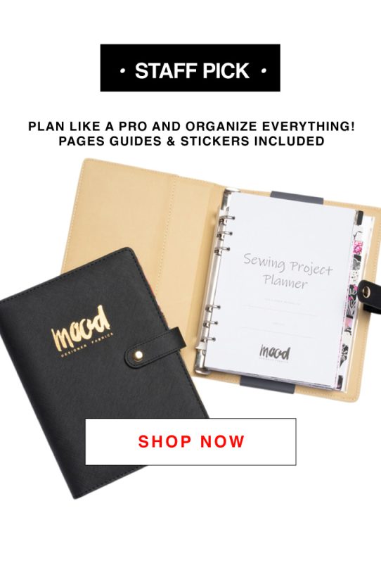 A black planner book with a notepad and pen next to it