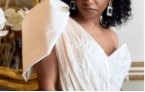 A close up of a woman in a white dress with a large hairdo