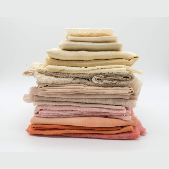 A close up of a stack of folded towels on a white surface