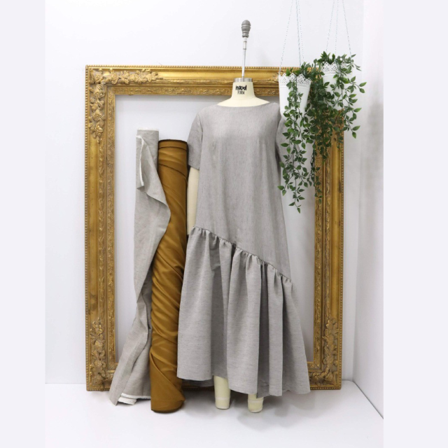 A dress on a mannequin next to a vase