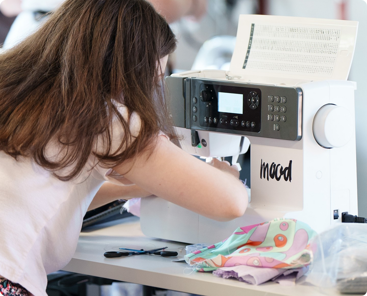 Woman working on a sewing machine at a table