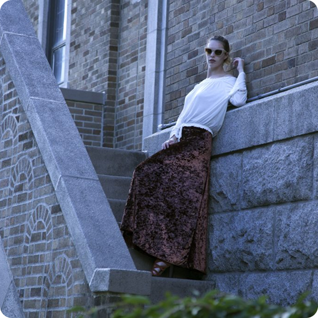 Woman leaning against a wall on a ledge