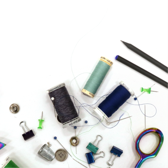 A close up of a table with a bunch of sewing supplies