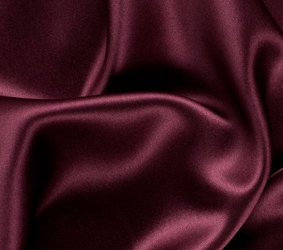 A close up of a maroon satin fabric