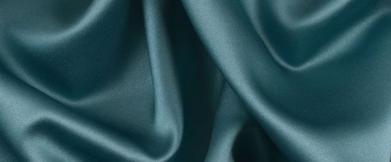 A close up of a blue silk fabric with a very large folds