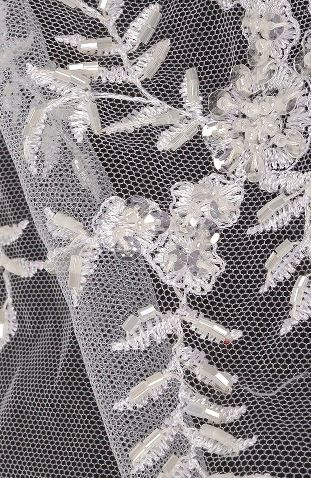A close up of a wedding veil with a flower design