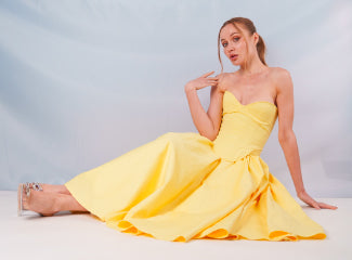 Woman in a yellow dress sitting on the floor