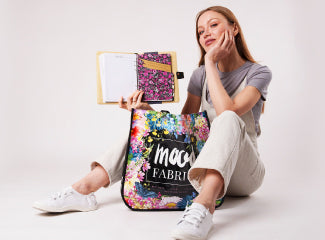 Woman sitting on the floor with a backpack and notebook